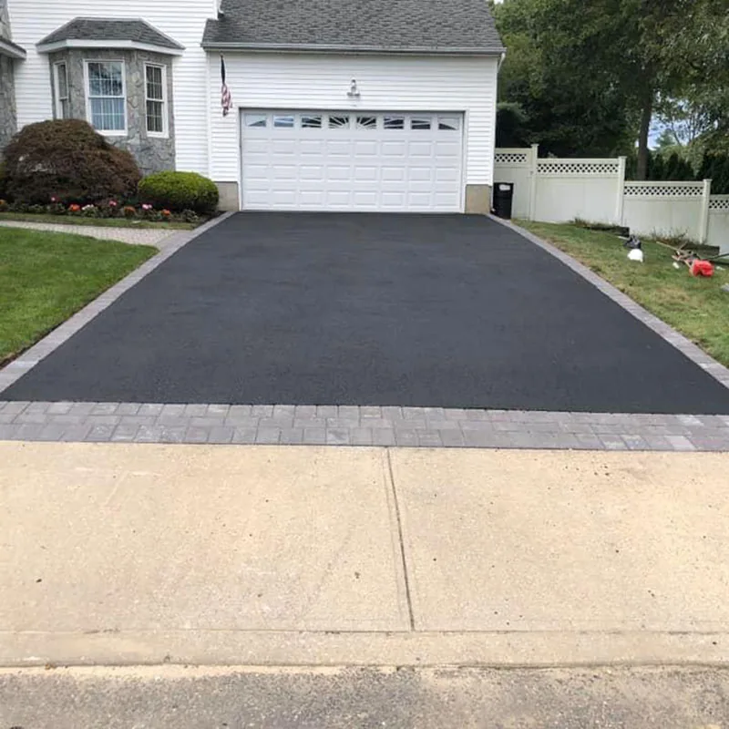 Asphalt driveway leading to a residential garage